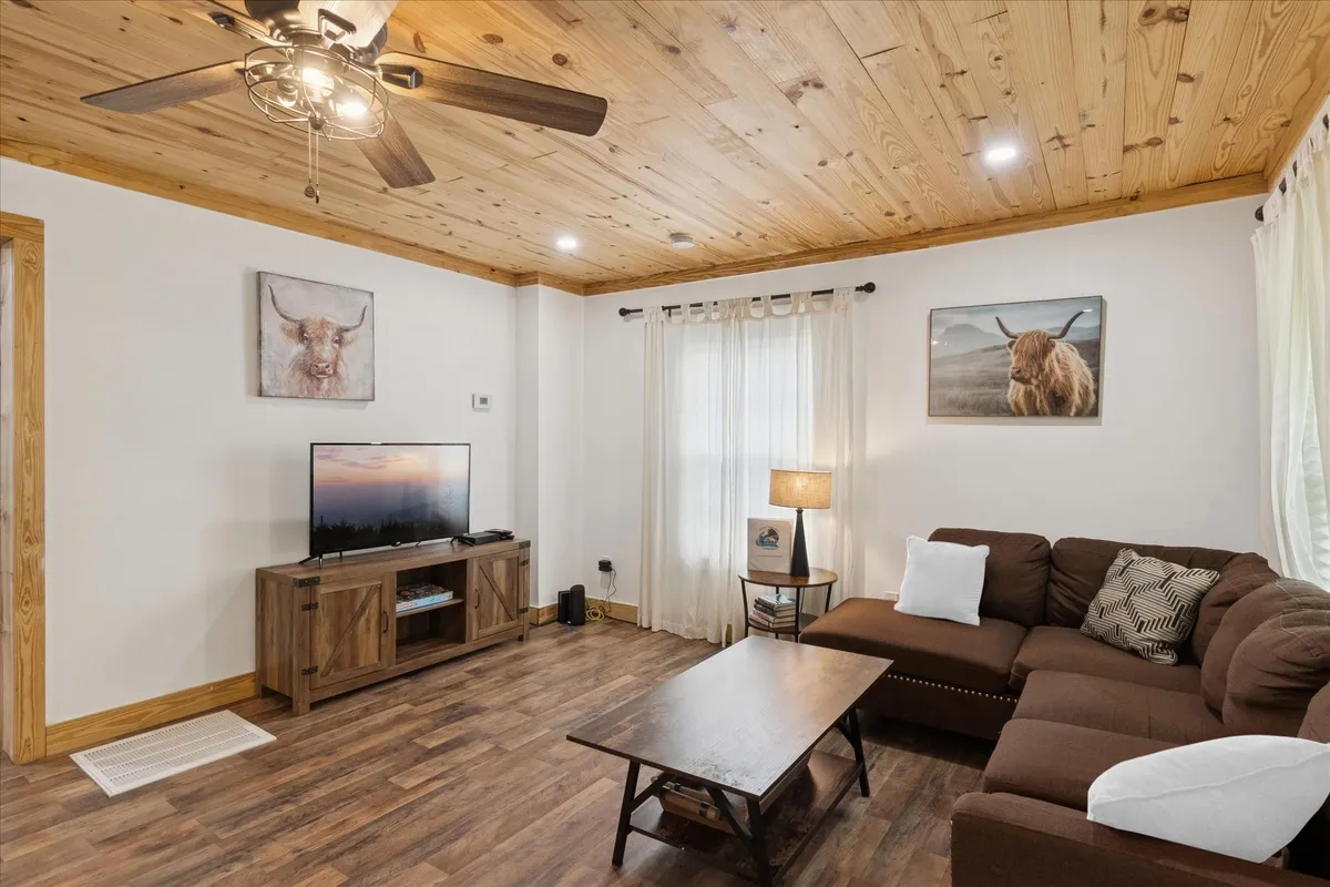 A cozy interior scene showing a plush sofa, a coffee table, a large TV, and artwork, all set in a warm and inviting living space. The room looks ready for movie nights, socializing, or simply unwinding after a busy day.